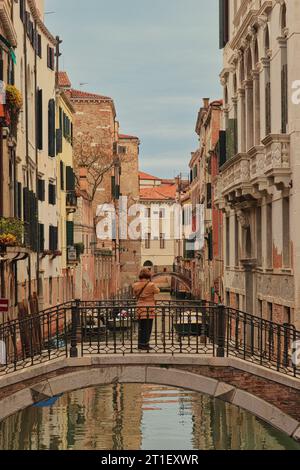 Eine alte Frau, die ein Foto von einer Venedig-Straße macht. Foto im April 2022 Stockfoto