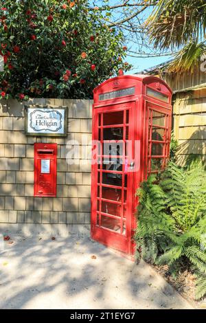 Ein roter Briefkasten oder Briefkasten und ein roter Telefonkiosk oder eine Telefonbox im Lost Gardens of Heligan Cornwall April 2021 Stockfoto