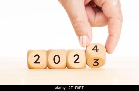 Neujahrskonzept. Händig klappt Holzblöcke von 2023 bis 2024 Jahren. Kopierbereich Stockfoto