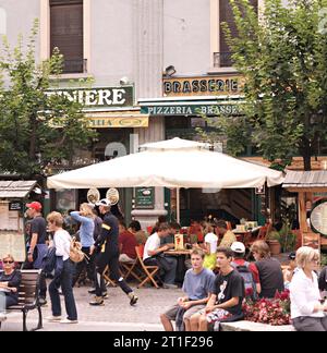 Chamonix-Mont-Blanc, Frankreich. Gebäude von Fassaden und Geschäften in der Altstadt, mit Touristen und Kunden sitzen an den Tischen eines Restaurants. Die Kombi Stockfoto