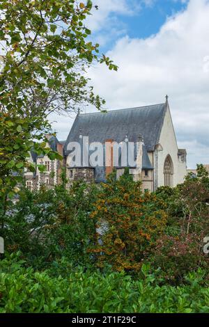 Angers, Frankreich, 2023. Die Kapelle und die spitzen Türme des Châtelet, die den Zugang zu den inneren Stationen durch das Laub (vertikal) steuern Stockfoto