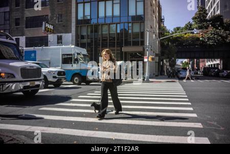 Eine Frau überquert die Tenth Avenue in Chelsea in New York am Donnerstag, den 5. Oktober 2023. (© Richard B. Levine) Stockfoto