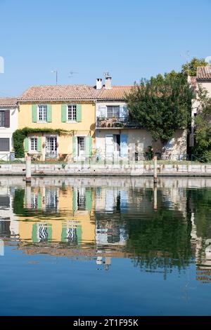 Aigues-Mortes in Occitanie, Frankreich, bietet eine bezaubernde Auswahl an farbenfrohen Häusern entlang des Rhonekanals Stockfoto