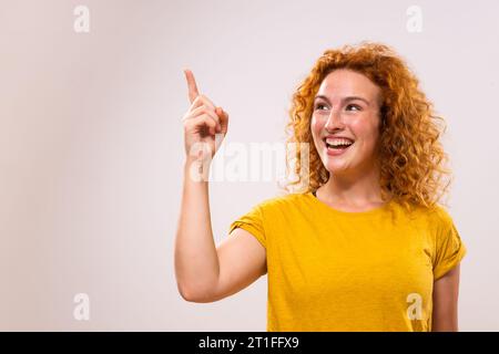 Bild einer glücklichen Ingwerfrau, die Idee hat und zeigt. Stockfoto