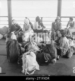 Die britische Wiederbesetzung von Hong Kong Japanischen zivilen Internierten warten am Hafen für den Transport, die Sie zu Stanley Camp, Hong Kong. Rund 3.000 japanische Zivilisten wurden von Kowloon nach Stanley Camp, das während des Krieges von der japanischen Besatzungsmacht als Internierungslager für Alliierte Zivilisten eingesetzt wurde verschoben. Stockfoto