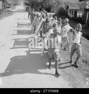 Die britische Wiederbesetzung von Singapur japanische Kriegsgefangene bewegen Blätter aus Metall von einem ordnance Depot in Singapur. Stockfoto