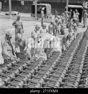 Die britische Wiederbesetzung von Singapur japanische Kriegsgefangene bei der Arbeit entladen Kanister voll Benzin in Singapur Docks. Stockfoto