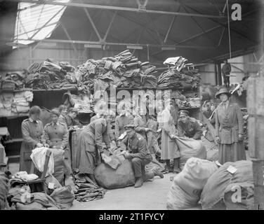 Olivenöl Edis; Iwm Fotograf der Leistungen der Frauen in Frankreich 1919 Mitglieder der QMAAC [Queen Mary's Army Auxiliary Corps] Seite an Seite mit den Soldaten in die Haufen von Kleidung in der Army Ordnance Depot an Vendraux. Stockfoto