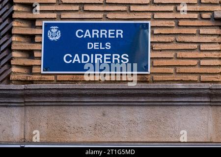 Valencia, Spanien - 23. September 2023: Informationstafel an der Wand eines Gebäudes. Straßenschild mit der Darstellung der Straße: Carrer dels Cadirers (València) Stockfoto