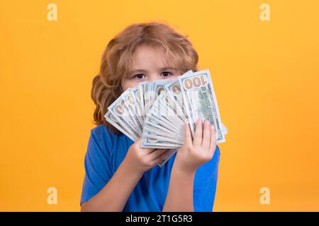 Das Kind hat viele hundert Dollar isoliert auf gelbem Hintergrund Stockfoto
