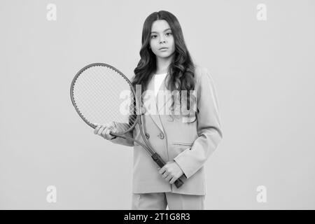 Teenager-Tennisspielerin, Mädchen, hält Tennisschläger auf einem isolierten gelben Hintergrund. Sport für Kinder. Training für ein kleines Kind. Kind lernt Tennis zu spielen Stockfoto