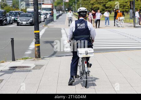 Tokio, Japan - 12. April 2023: Unbekannter Polizist auf einem Fahrrad in Tokio. Tokio ist die Hauptstadt und die bevölkerungsreichste Präfektur Japans Stockfoto