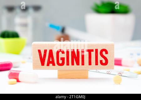 Auf dem Desktop befinden sich ein Stethoskop, Dokumente, ein Stift und ein roter Dateiordner mit dem Text VAGINITIS. Medizinisches Konzept. Stockfoto