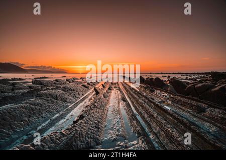 Der unglaubliche Flysch, ein wunderschöner Sonnenuntergang in Sakoneta, ist ein Strand in Deba. Es ist das westliche Ende des Geoparks der Baskenküste in Guipuzkoa Stockfoto