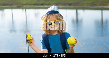 Kindertouristen mit Rucksäcken. Abenteuer-, Reise- und Tourismuskonzept. Ein Kind, das mit Rucksäcken in der Natur spaziert. Kleiner Entdecker auf der Reise Stockfoto