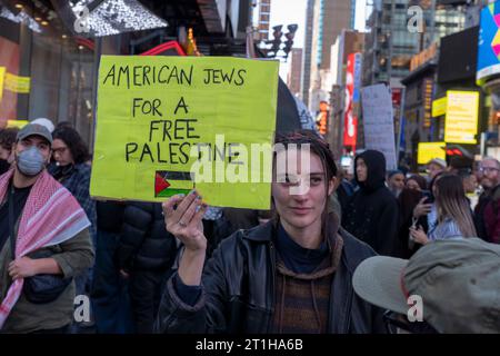 New York, Usa. Oktober 2023. NEW YORK, NEW YORK - 13. OKTOBER: Eine Frau hält während eines Palästinenserprotests am Times Square am 13. Oktober 2023 in New York City einen „amerikanischen Juden für Ein freies Palästina“ und unterschreibt während eines „Day of Action“-Protestes am Times Square. Im ganzen Land und auf der ganzen Welt halten Menschen Kundgebungen und Mahnwachen für Palästinenser und Israelis ab, nachdem die Hamas am 7. Oktober einen Überraschungsangriff erlitten hatte. Der Angriff hat zu einer Bombardierung des Gazastreifens durch das israelische Militär und zu einer möglichen Bodeninvasion des Territoriums geführt. Quelle: Ron Adar/Alamy Live News Stockfoto