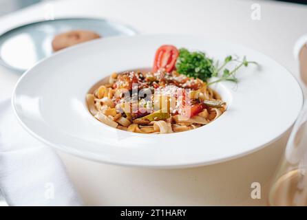 Udon-Nudeln mit Sesamsamen und Kräutern in weißer Seitenansicht Stockfoto