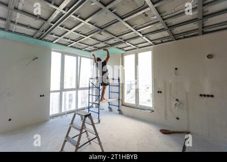 Drywall Installers. Men holding a gypsum board figured cut Stockfoto