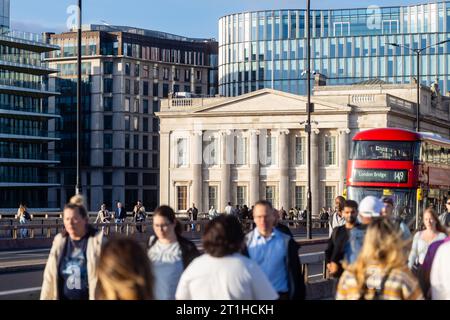 Nicht erkennbare Menschen laufen über die London Bridge, die Fischmonger's Hall im Hintergrund. Stockfoto