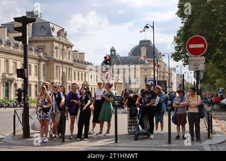 Fußgänger warten auf das grüne Licht, um die Straße am Fußgängerübergang überqueren zu können. Paris, Frankreich Stockfoto