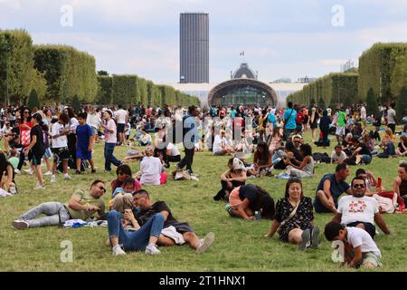 Die Leute sitzen entspannt auf dem Rasen der Champs de Mars in Paris, Frankreich Stockfoto