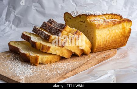 Geschnittener Cupcake auf Holzbrett und weißem Teller Stockfoto
