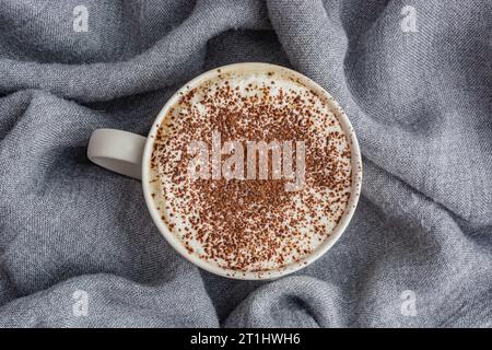 Tasse Kaffee auf grauem Stoffhintergrund, Draufsicht Stockfoto