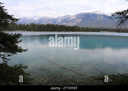 Goldener Sonnenuntergang zur blauen Stunde am Pyramid Lake im Jasper National Park, Alberta, Kanada. Die Wolken spiegeln sich vom ruhigen Wasser. Stockfoto