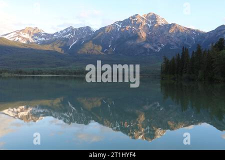 Goldener Sonnenuntergang zur blauen Stunde am Pyramid Lake im Jasper National Park, Alberta, Kanada. Die Wolken spiegeln sich vom ruhigen Wasser. Stockfoto