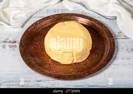 Butter in einer Kupferplatte. Frische Bio-Kuhbutter auf Holzhintergrund Stockfoto