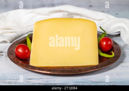 Gereifter Käse auf einer Kupferplatte. Organischer frischer Kuh Cheddar auf Holzhintergrund Stockfoto