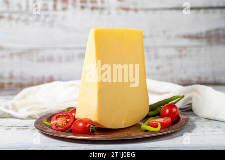 Gereifter Käse auf einer Kupferplatte. Organischer frischer Kuh Cheddar auf Holzhintergrund Stockfoto