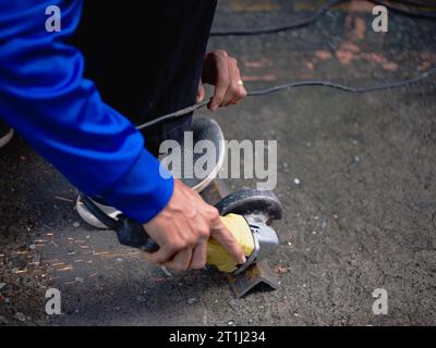 Industriearbeiter mit Winkelschleifer und Schneiden eines Metalls Stockfoto