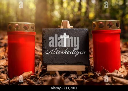 Augsburg, Bayern, Deutschland. Oktober 2023. Allerheiligen Feiertag, Eine Grabkerze im Wald mit einer Tafel mit Text: Allerheiligen Tag FOTOMONTAGE *** Allerheiligen Feiertag, eine Grabkerze im Wald mit einer Tafel mit Text: Allerheiligen FOTOMONTAGE Credit: Imago/Alamy Live News Stockfoto