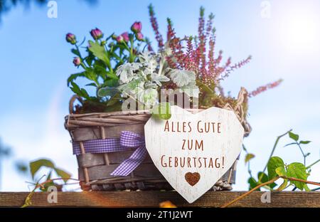 Augsburg, Bayern, Deutschland. Oktober 2023. Alles Gute zum Geburtstag Gruß auf einem Herzen von einem Blumengesteck in lila Farben FOTO MONTAGE *** alles Gute zum Geburtstag Gruß auf einem Herz bei einem Blumengesteck in lila Farben FOTOMONTAGE Credit: Imago/Alamy Live News Stockfoto