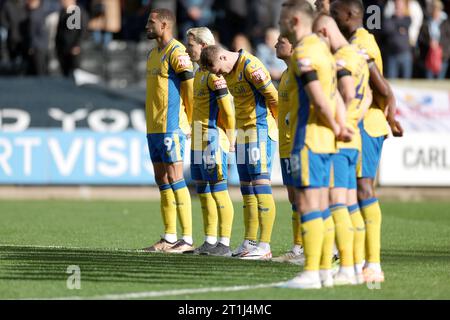 Die Spieler von Mansfield Town halten vor dem Spiel der Sky Bet League Two in der Meadow Lane, Nottingham, eine Schweigeminute für die Opfer des israelisch-palästinensischen Konflikts ein. Bilddatum: Samstag, 14. Oktober 2023. Stockfoto