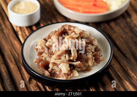 Nahaufnahme von koreanischem Essen Bulgogi in Scheiben geschnittenes und gewürztes gegrilltes Rindfleisch auf Keramikplatte Stockfoto