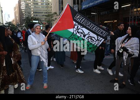 Eine Frau winkt mit dem Spruch „Freies Palästina“, während Hunderte sich am Times Square versammeln, um gegen den anhaltenden Krieg zwischen Israel und der Hamas in New York City am 13. Oktober 2023 zu protestieren. (Foto: Gordon Donovan) Stockfoto