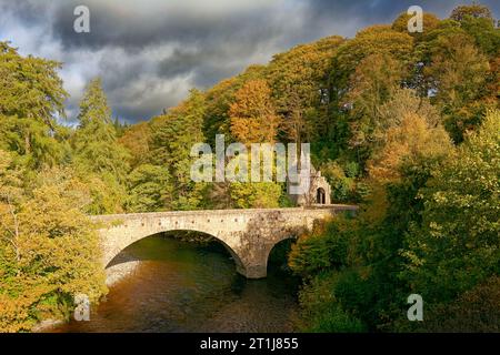 Brücke von Avon über den Fluss Avon bei Ballindalloch in Moray die Torhütte und Fluss mit Bäumen in Herbstfarben Stockfoto