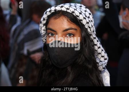 Eine junge Palästinenserin mit Keffiyeh nimmt an einem Protest auf dem Times Square Teil, als Reaktion auf den Krieg zwischen Israel und der Hamas am 13. Oktober 2023 in New York City stattfand. (Foto: Gordon Donovan) Stockfoto