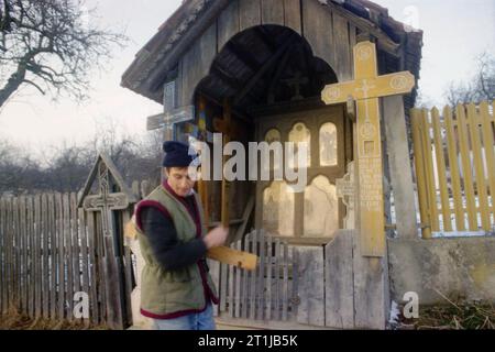 Tutana, Landkreis Arges, Rumänien, 2000. Ein Dorfbewohner überquert sich selbst, während er an einem Kruzifix am Straßenrand vorbeifährt. Stockfoto