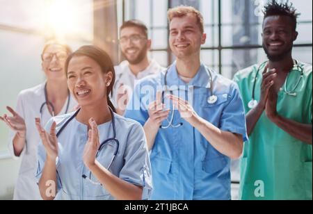 Professionelle multinationale Ärzte applaudieren vor der Kamera. Diagnosediskussion Stockfoto