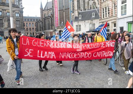 Amsterdam, Niederlande. Oktober 2023. Mitglieder verschiedener indigener Gemeinschaften, darunter West-Papua, Suriname, und Andengemeinschaften versammeln sich am Damm zu einem marsch unter dem Banner der indigenen Befreiungsbewegung Banner La Guerra contra los pueblos de Mexico se llama narcoestado capitalista der Krieg gegen die Völker Mexikos im Namen kapitalistischer Narkostate inheemse volkeren, Protest, Diaspora, Credit: Imago/Alamy Live News Stockfoto