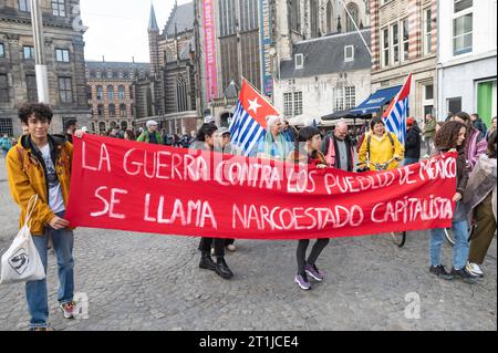 Amsterdam, Niederlande. Oktober 2023. Mitglieder verschiedener indigener Gemeinschaften, darunter West-Papua, Suriname, und Andengemeinschaften versammeln sich am Damm zu einem marsch unter dem Banner der indigenen Befreiungsbewegung Banner La Guerra contra los pueblos de Mexico se llama narcoestado capitalista der Krieg gegen die Völker Mexikos im Namen kapitalistischer Narkostate inheemse volkeren, Protest, Diaspora, Credit: Imago/Alamy Live News Stockfoto