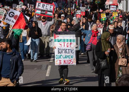 Whitehall, London, Großbritannien. Oktober 2023. Während der Konflikt zwischen Israel und der Hamas anhält, findet ein Protest gegen die Eskalation der militärischen Aktionen im Gazastreifen statt. Organisiert von Gruppen wie der Palästinensischen Solidaritätskampagne und der Stop the war Coalition mit dem Titel „nationale Demonstration: Marsch für Palästina“ und mit Aufrufen zur „Beendigung der Gewalt“ und „Beendigung der Apartheid“ versammelten sich die Demonstranten vor der BBC in Portland Place und marschieren nach Whitehall. Hör auf, ein Plakat zu bombardieren Stockfoto