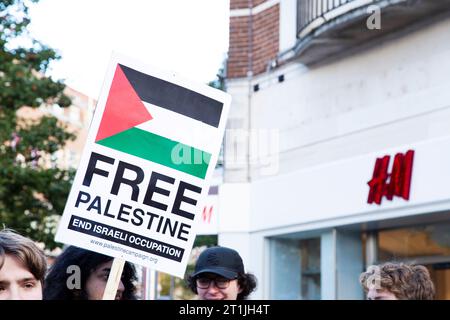 Freier palästinensischer Protest im Stadtzentrum von Exeter - kostenloses palästinensisches Schild neben dem H&M Shop Logo mit Köpfen Stockfoto