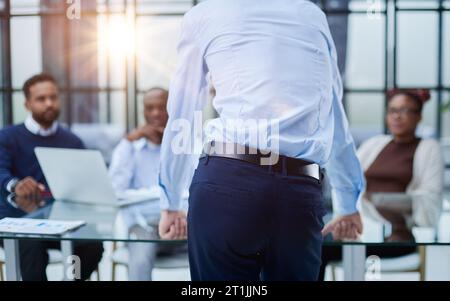 Junger Mitarbeiter, der um Rat von seinen hilfsbereiten, erfahrenen Kollegen im Büro bittet Stockfoto