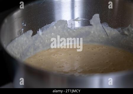 Ein Porträt eines Topfes voller flüssigem belgischem Waffelteig, hergestellt aus einer Mischung aus Zucker, selbsterziehender Blume, ein paar Eiern und einer Prise Salz. Bereit für dich Stockfoto