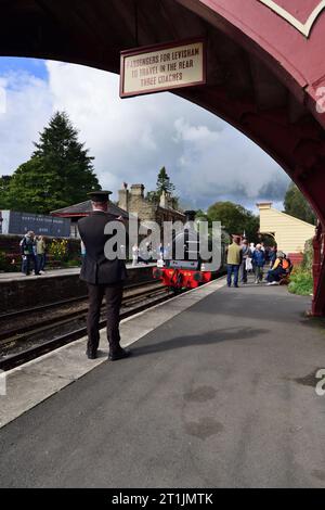 Menschen beobachten eine Dampfeisenbahn, die während ihrer 50-jährigen Jubiläumsgala am Bahnhof Goathland der North Yorkshire Moors Railway ankommt. Stockfoto