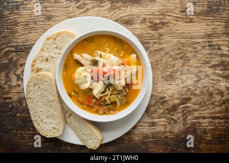 Eine Fischsuppe mit Safran, die Seezungenfilets aus Dover, Gurnardfilets und Garnelen aus Wildfang enthält. Dorset England GB Stockfoto